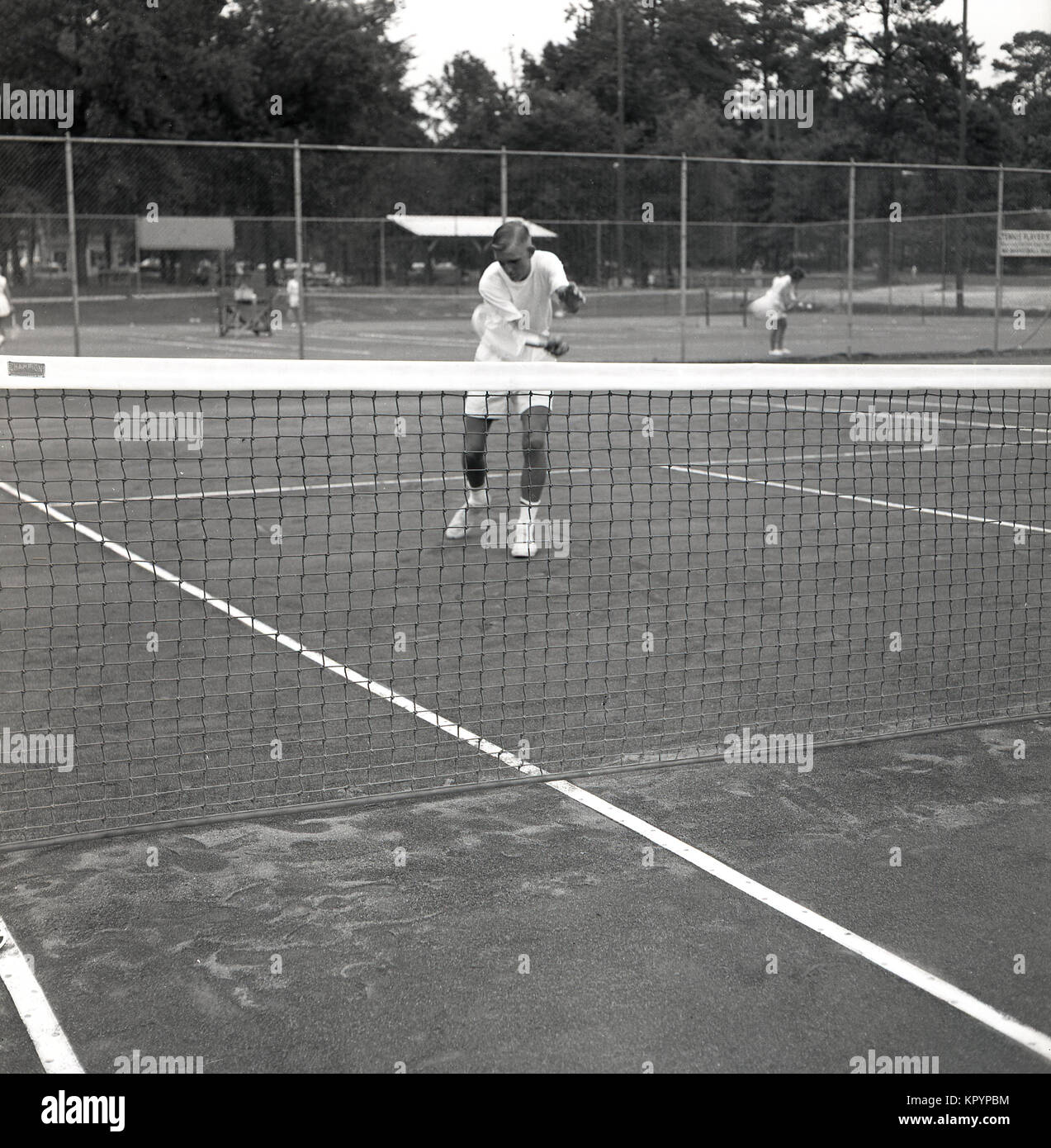 Années 1960, historique, photo montre un jeune joueur de tennis adultes au filet se concentrant sur une balle volée, USA. Banque D'Images