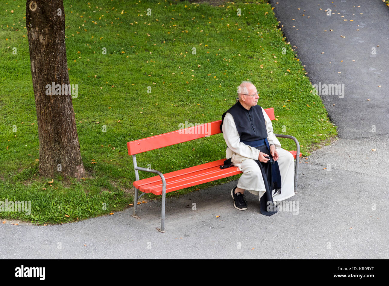 Un vieux moine assis sur un beanch dans Stift Stams, une abbaye cistercienne baroque dans la municipalité de Stams, état de l'ouest de l'Autriche, Tyrol Banque D'Images