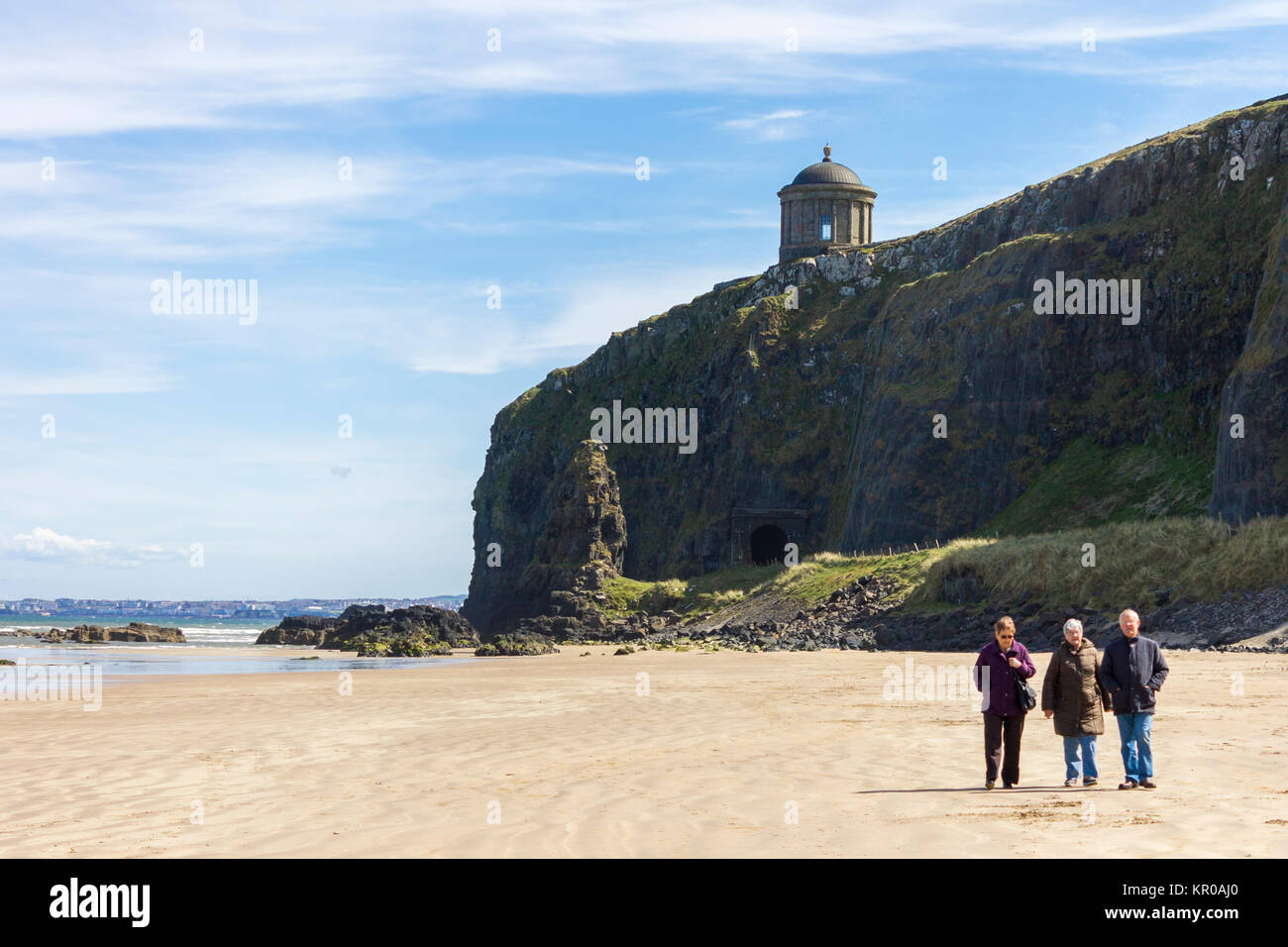 Les gens qui marchent en descente plage, avec l'emblématique Temple Mussenden au sommet des falaises. Le comté de Derry, Castlerock, Irlande du Nord Banque D'Images