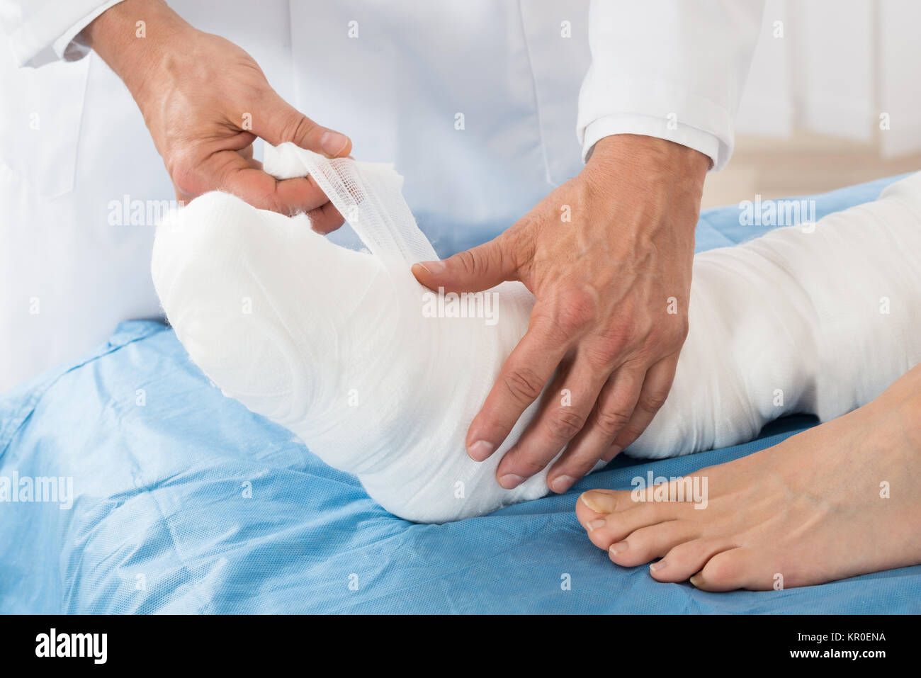 Liage médecin Bandage sur la jambe du patient Banque D'Images