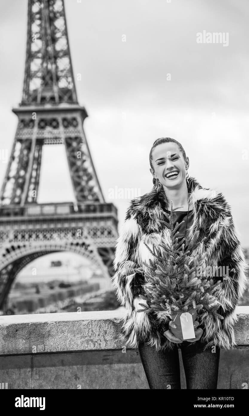 La saison des festivals à Paris. Portrait de femme à la mode heureux avec l'arbre de Noël en manteau de fourrure dans l'avant de la tour Eiffel à Paris, France Banque D'Images