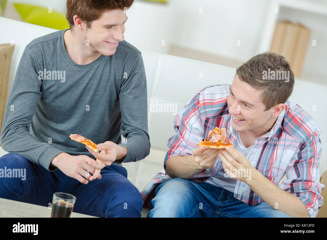 Les amis partageant une pizza à la maison Banque D'Images