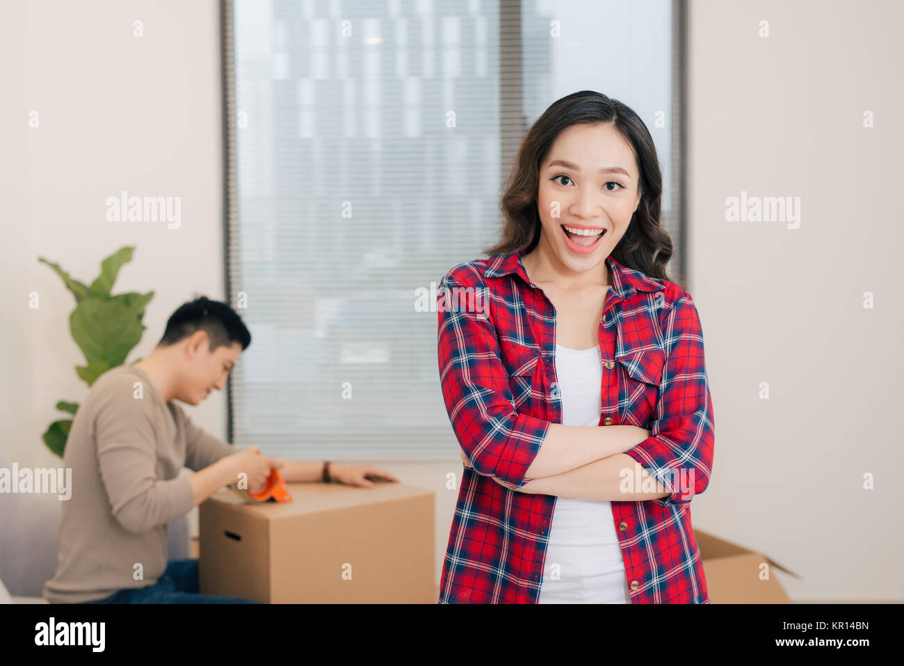 Portrait de femme heureuse pendant le déménagement transportant des boîtes en carton Banque D'Images