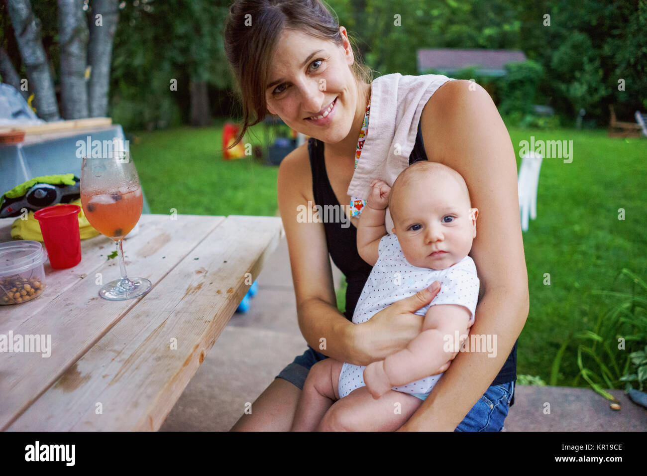 Assis dans le jardin de la mère avec son bébé garçon Banque D'Images