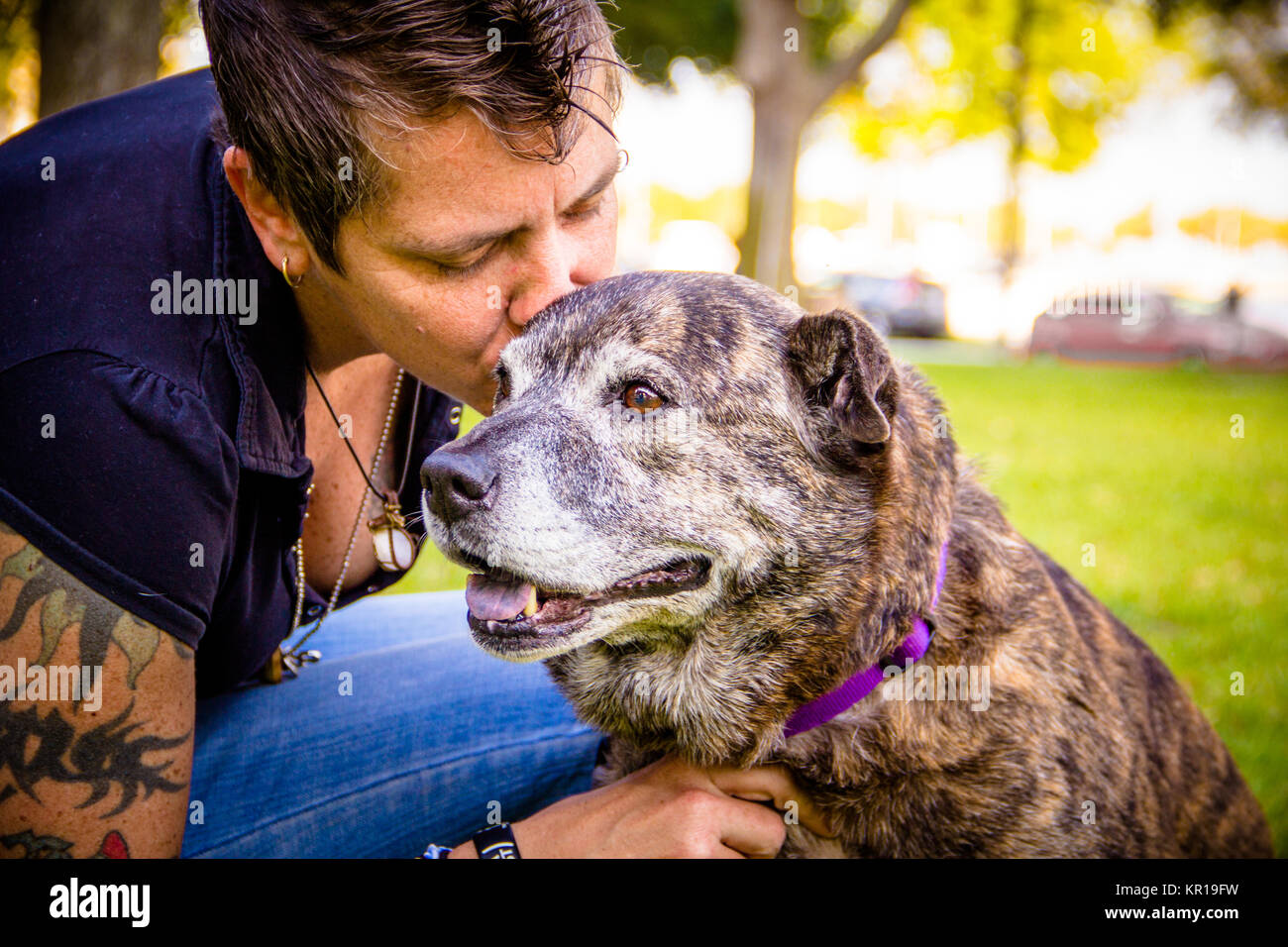 Femme dans le parc embrassant son chien de Pitbull, Saint-Pétersbourg, Floride, États-Unis Banque D'Images