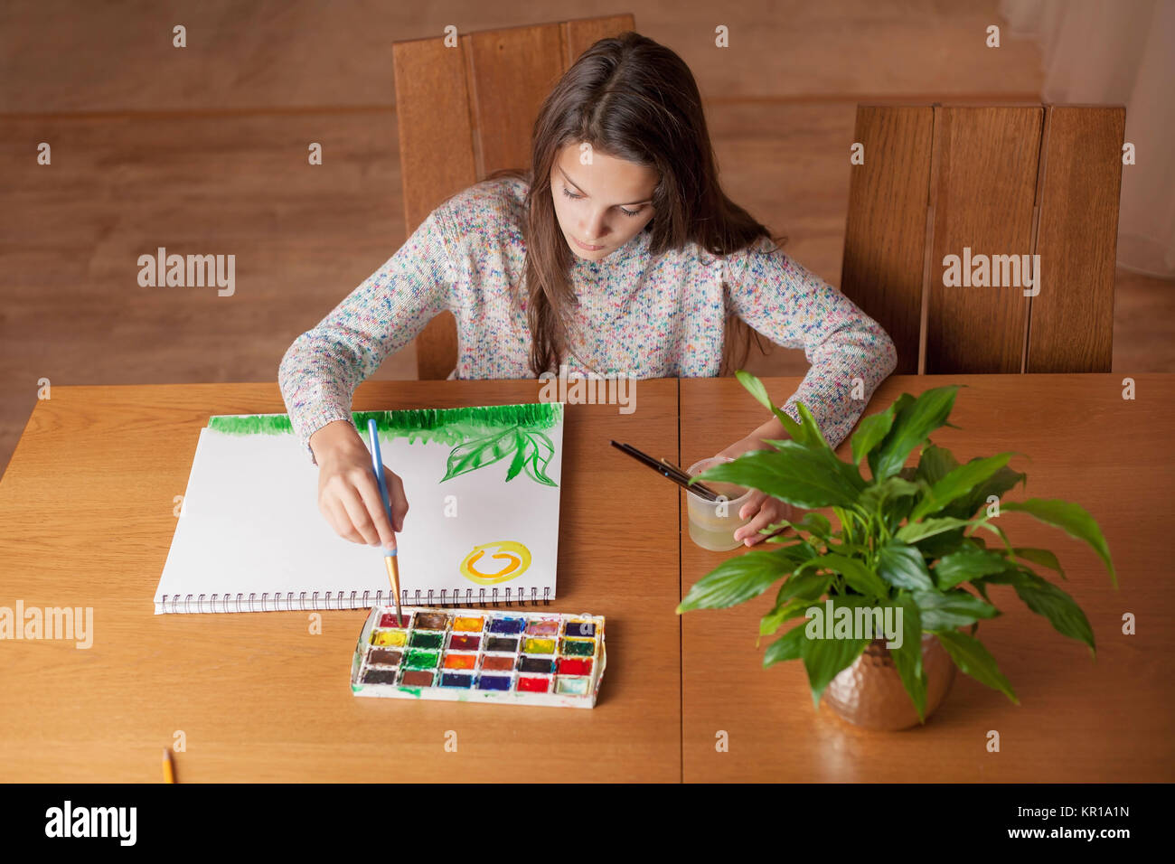 Fille assise à une table peinture Banque D'Images