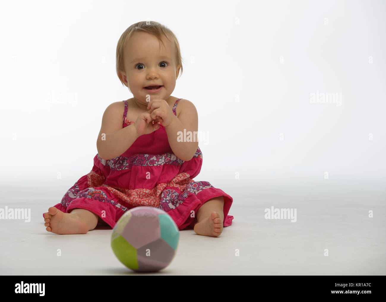 Bébé fille jouant avec une balle jouet Banque D'Images
