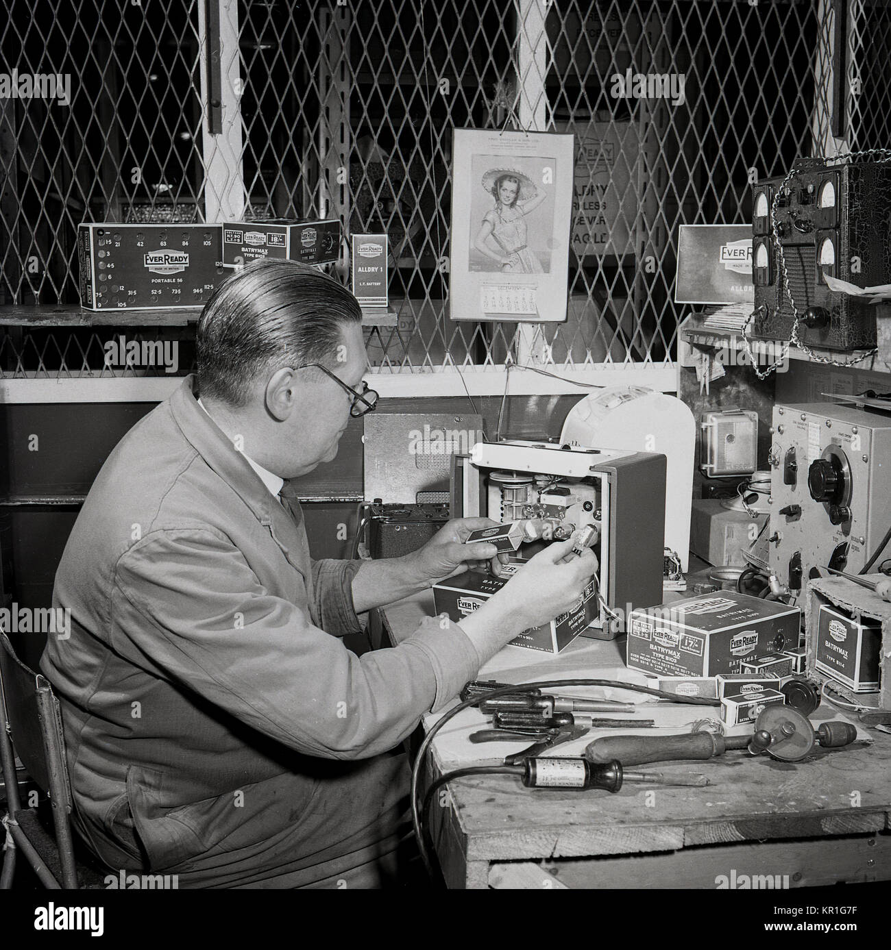 1950, historique, un homme d'essais technicien 'Jamais' piles et vannes radio à un établi, England, UK. Banque D'Images