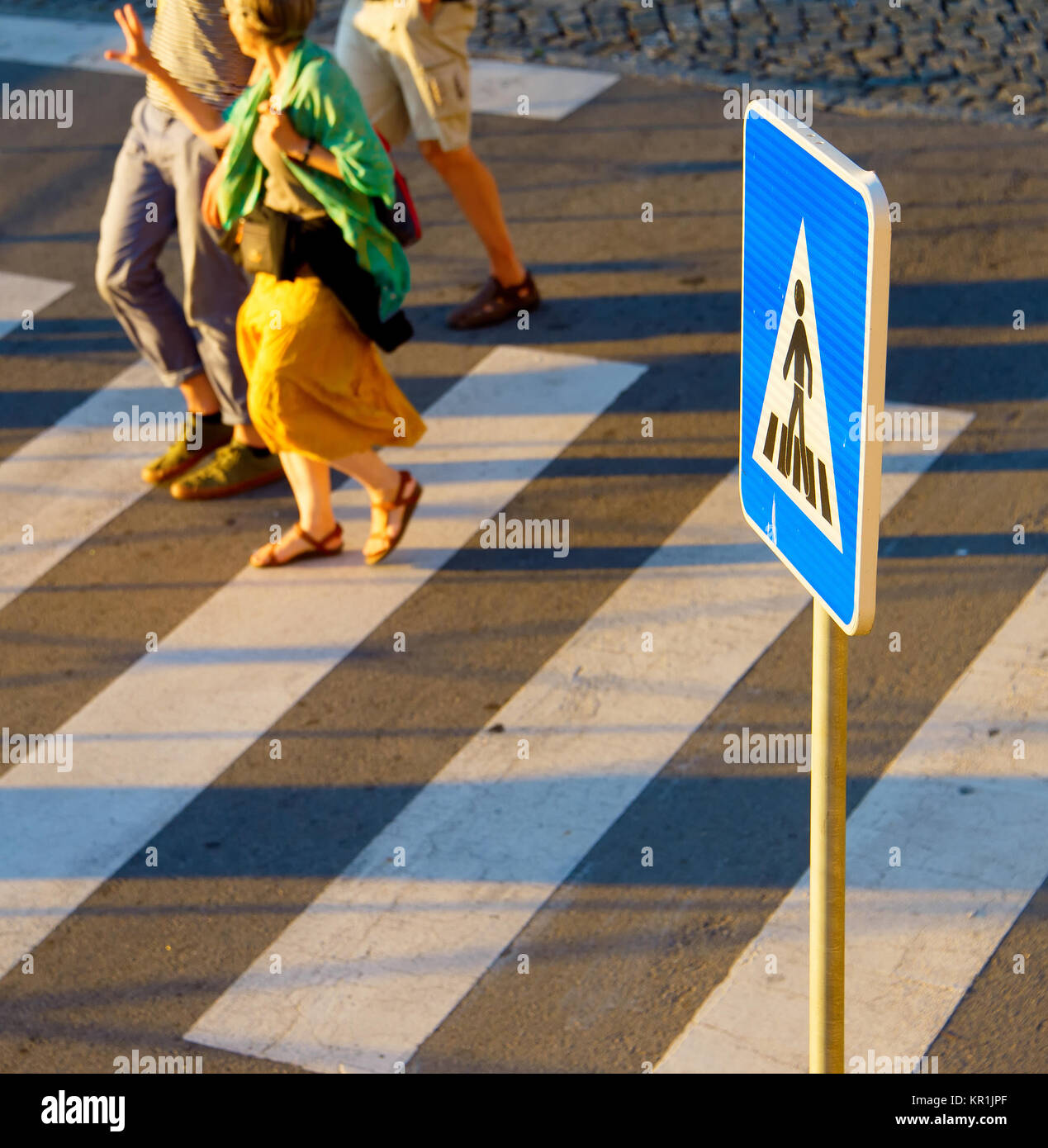 Les personnes qui traversent une route sur un passage pour piétons. Se concentrer sur un signe Banque D'Images