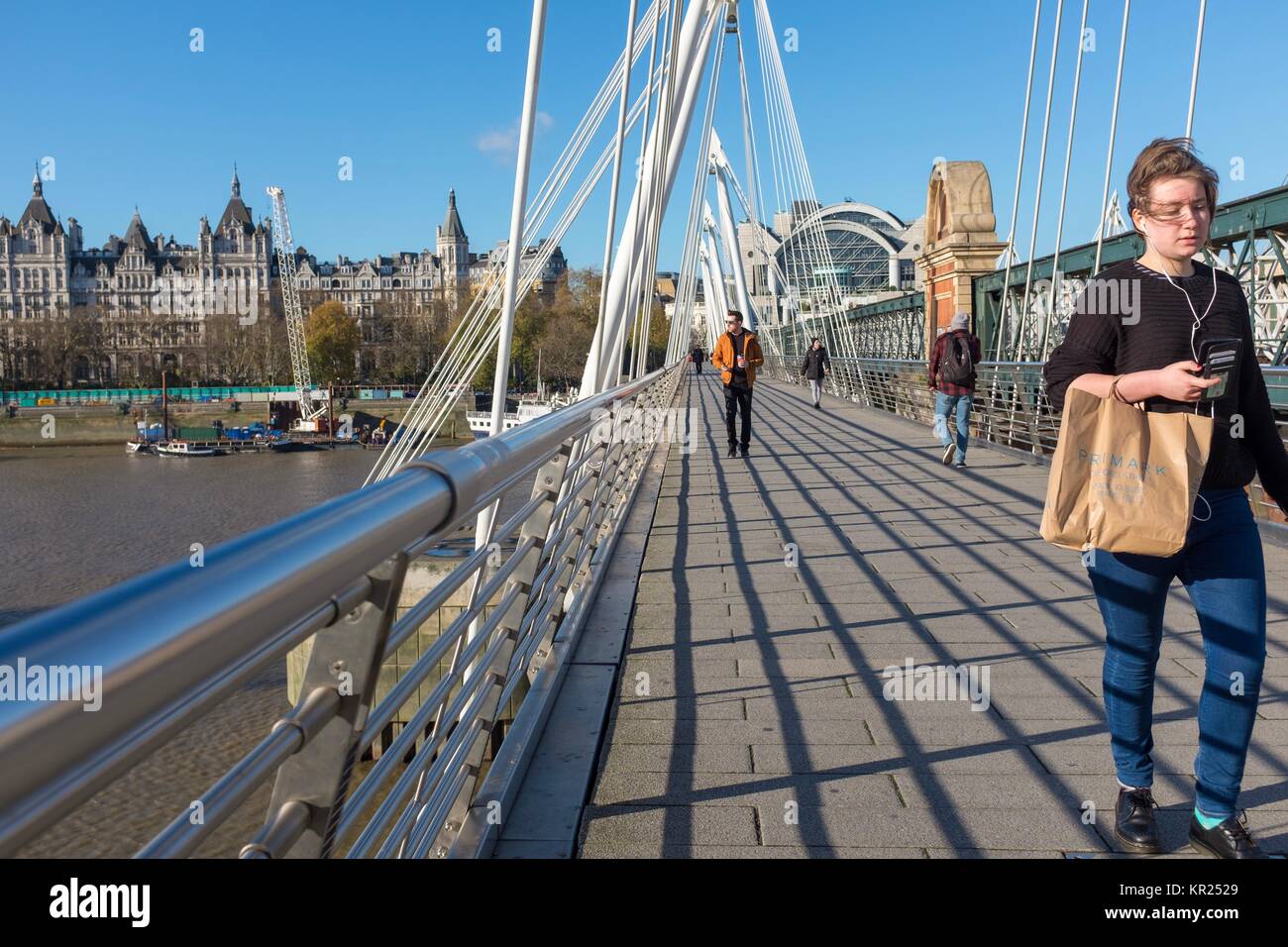 Une femme marche sur Waterloo Bridge à Londres pendant l'écoute d'un Iphone Banque D'Images