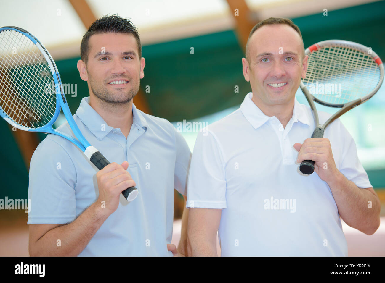 Deux hommes avec des raquettes de tennis sur leurs épaules Banque D'Images