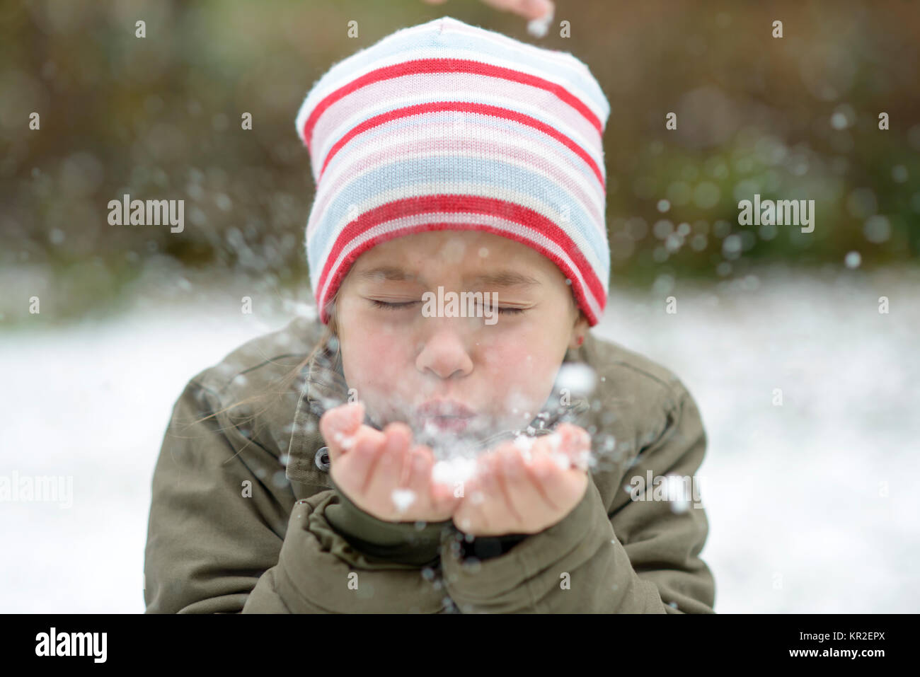 Fille de la poudrerie à partir de leurs mains en hiver, Upper Bavaria, Bavaria, Germany Banque D'Images