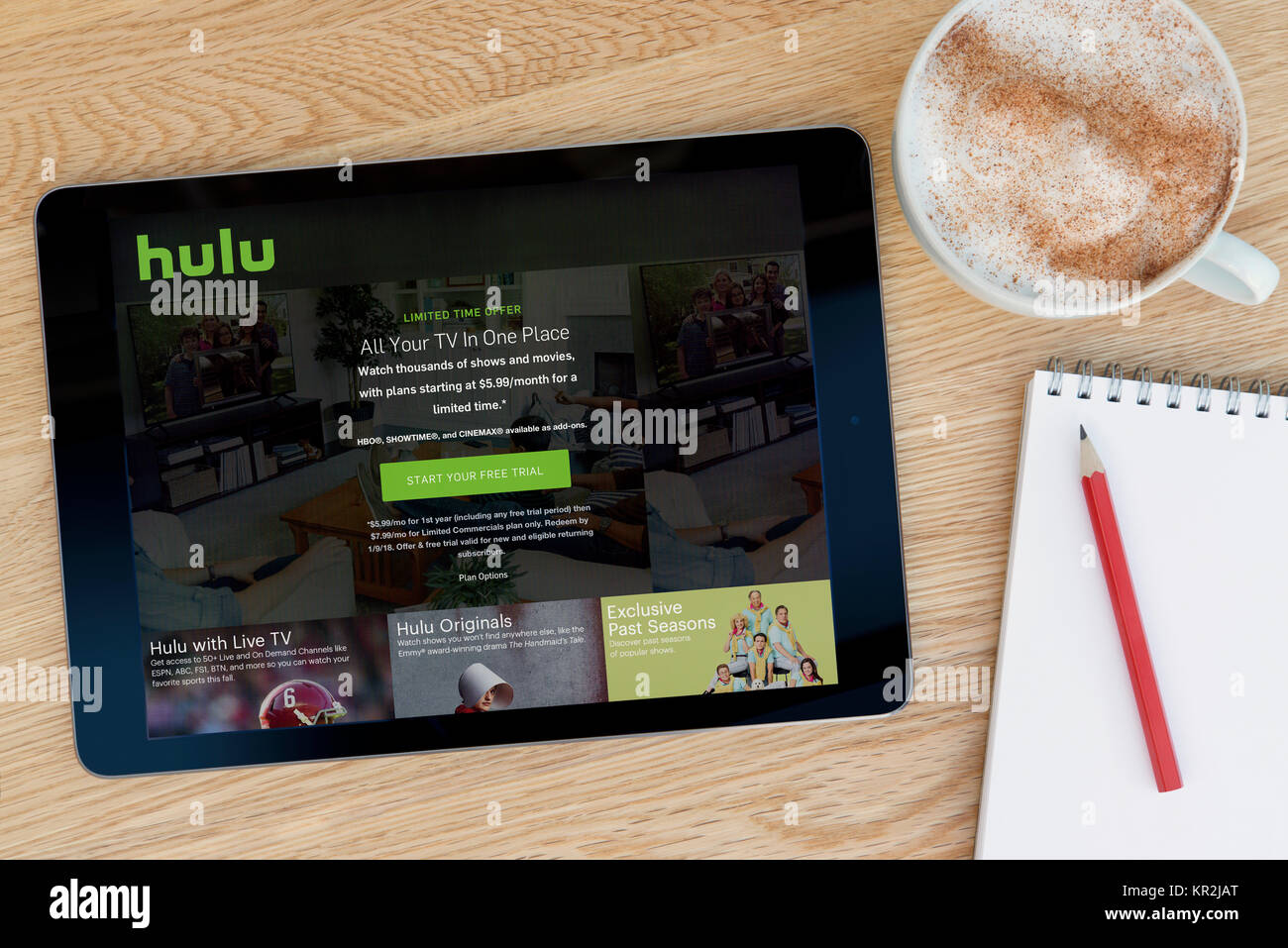 Le site Hulu sur iPad tablet device qui repose sur une table en bois à côté d'un bloc-notes et un crayon et une tasse de café (rédaction uniquement) Banque D'Images