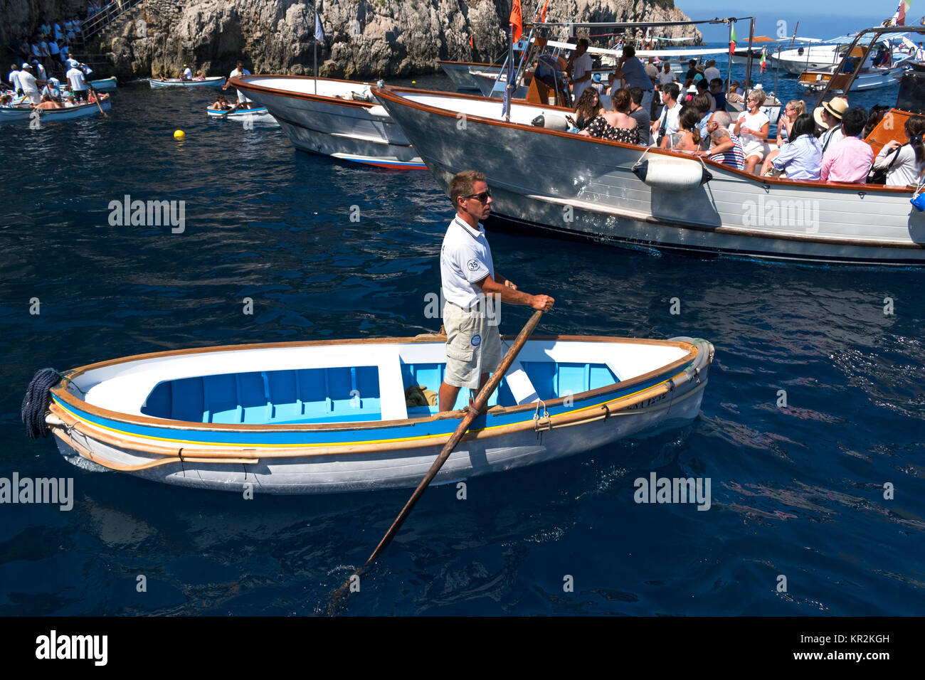 Un guide attend dans son bateau pour transporter les touristes dans la célèbre grotte bleue sur l'île de cpari, Italie. Banque D'Images