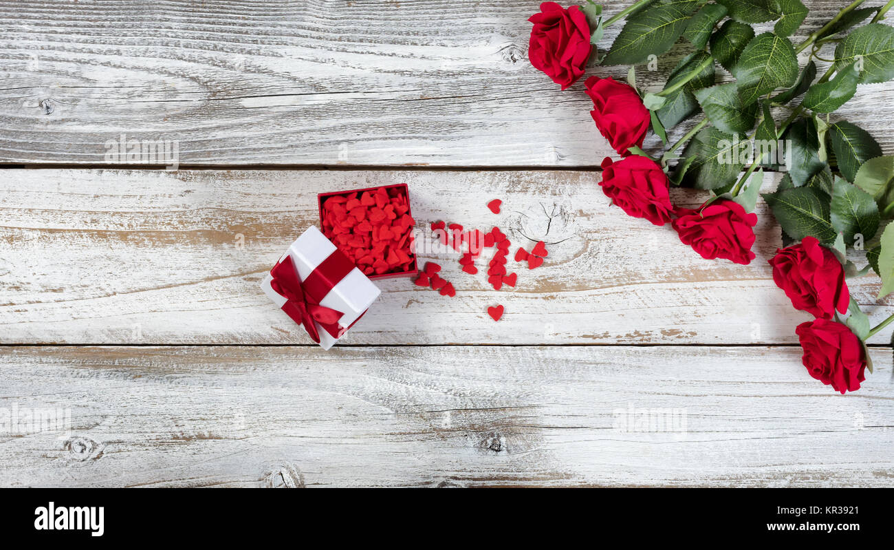 Boîte-cadeau rempli de bonbons en forme de coeur et roses rouges Banque D'Images