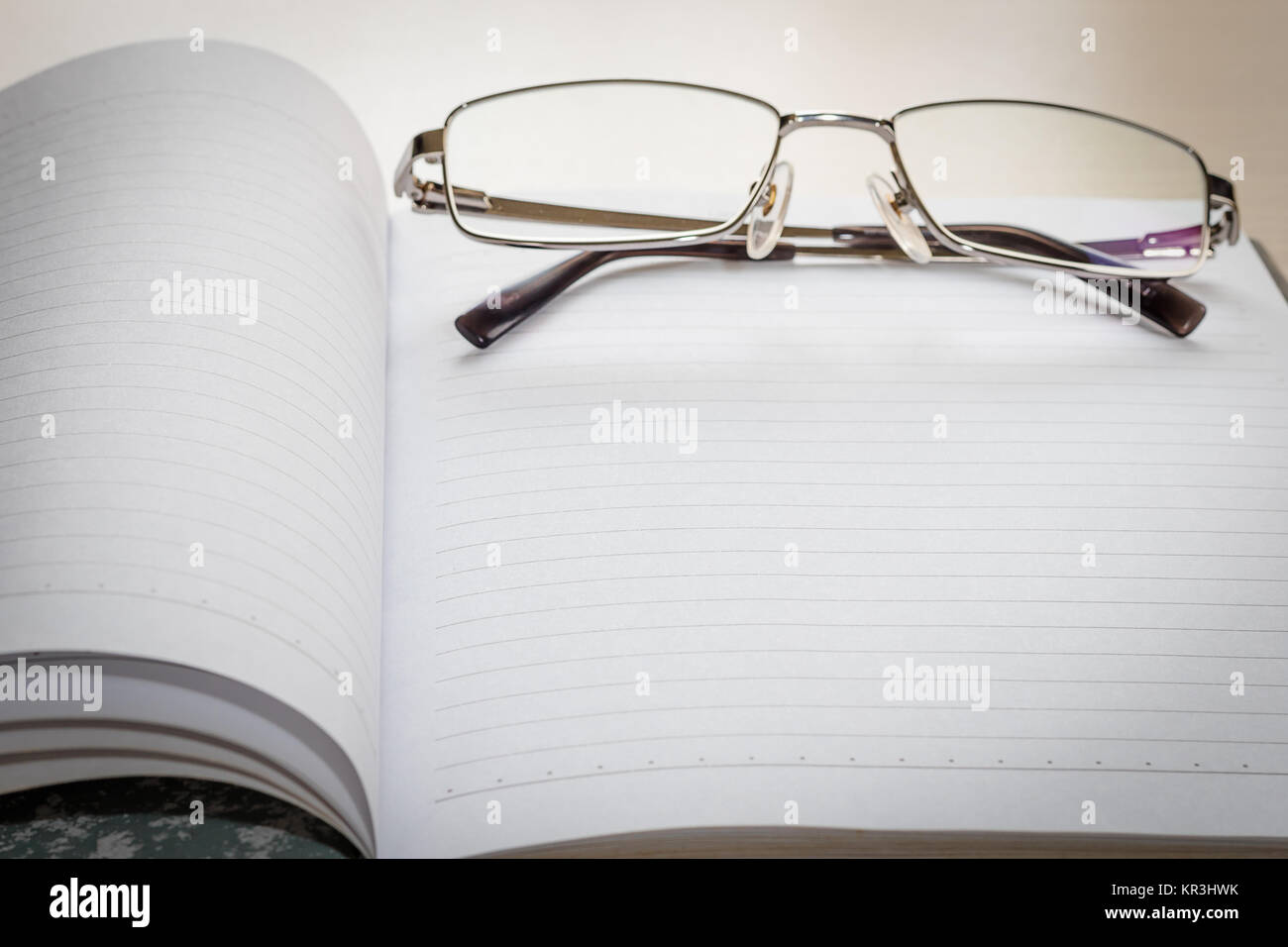 Les lunettes et le bloc-notes avec page blanche Banque D'Images