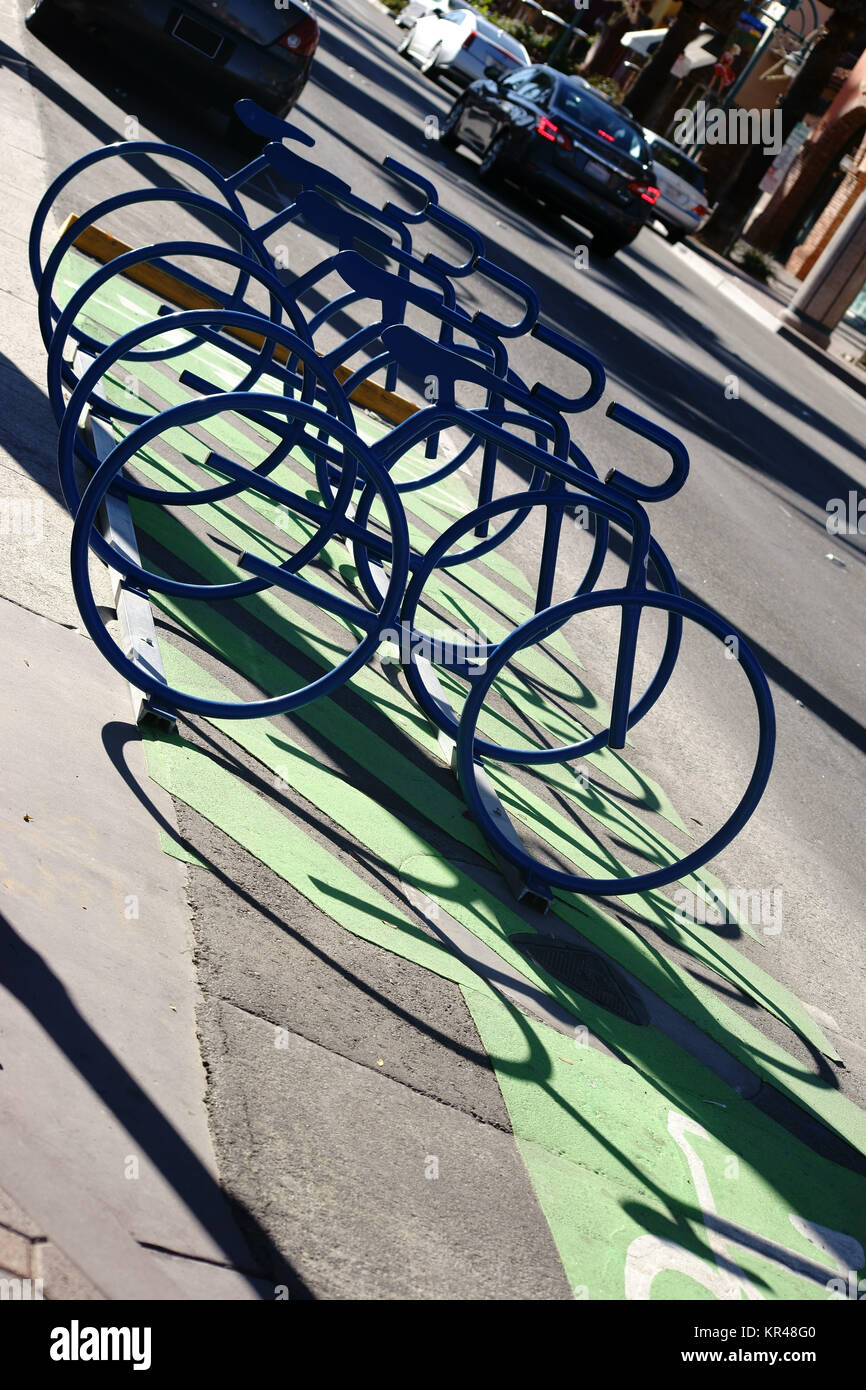 Abstrakte dans Reihe angeordnete Fahrradständer werfen einen Schatten und haben die Form von Rennrades. Banque D'Images