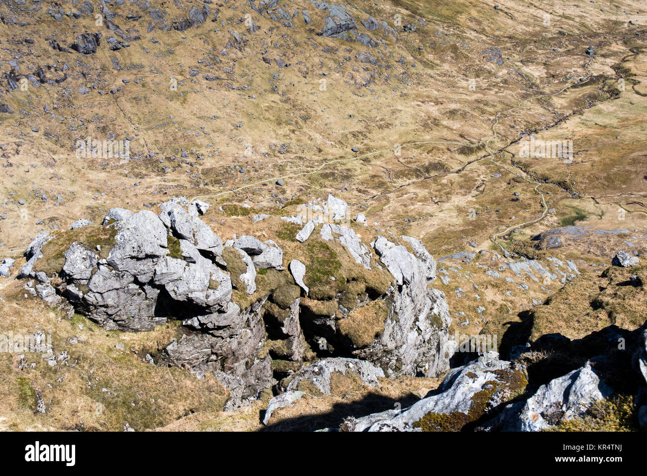 Le soleil brille sur les falaises abruptes et craggs haut au-dessus d'une vallée marécageux sur Beinn Artair, "le cordonnier", une montagne dans le sud-ouest des Highlands d'Écosse. Banque D'Images