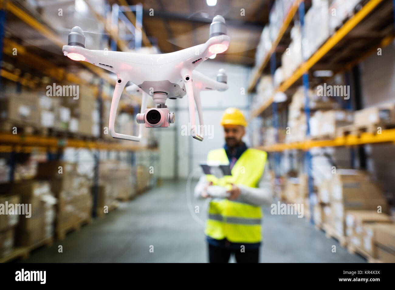 Homme avec drone dans un entrepôt. Banque D'Images