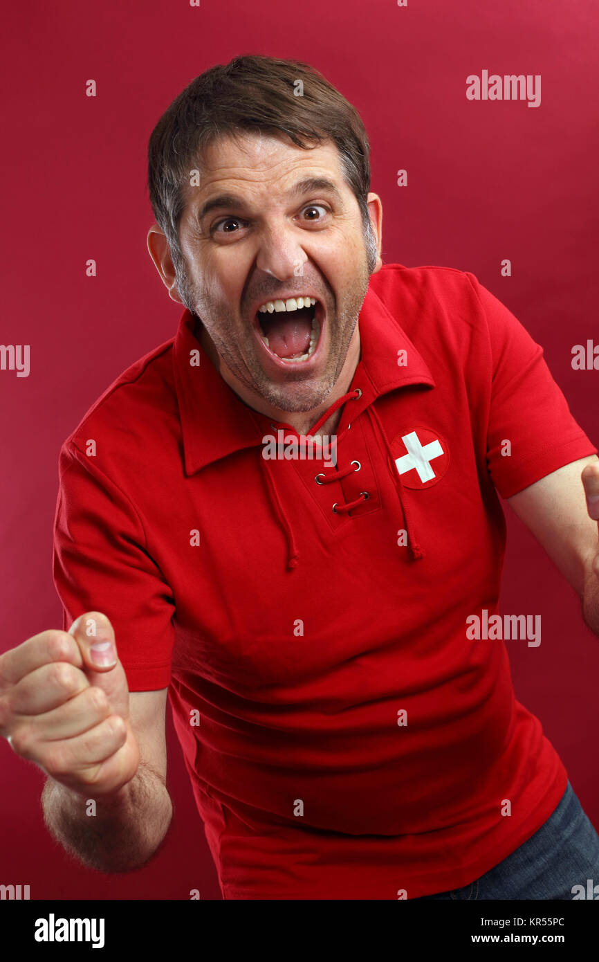 Photo d'un homme Swiss sports fan portant un drapeau suisse shirt et criant pour son équipe. Banque D'Images