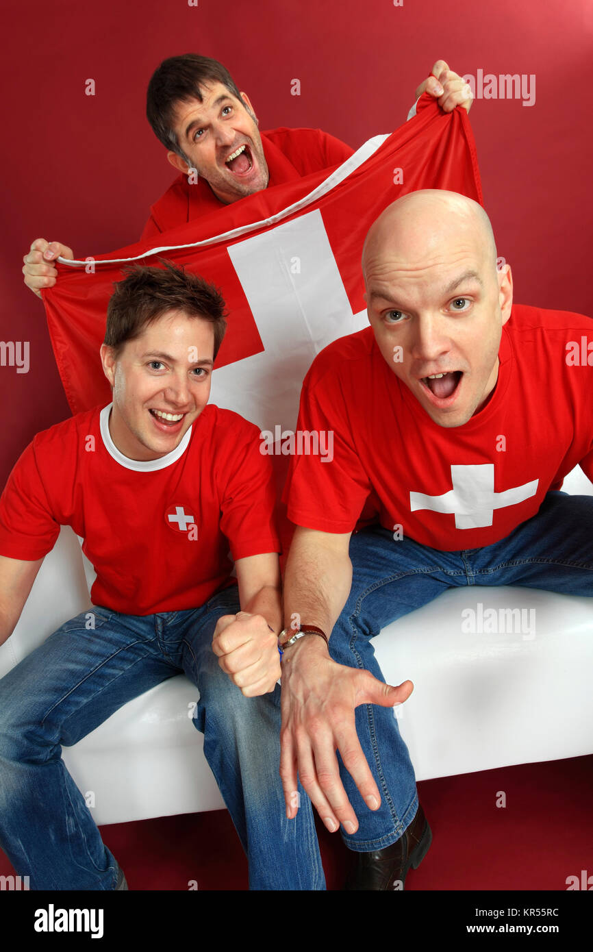 Photo de trois sports fans cheering Suisse mâle pour leur équipe. Banque D'Images