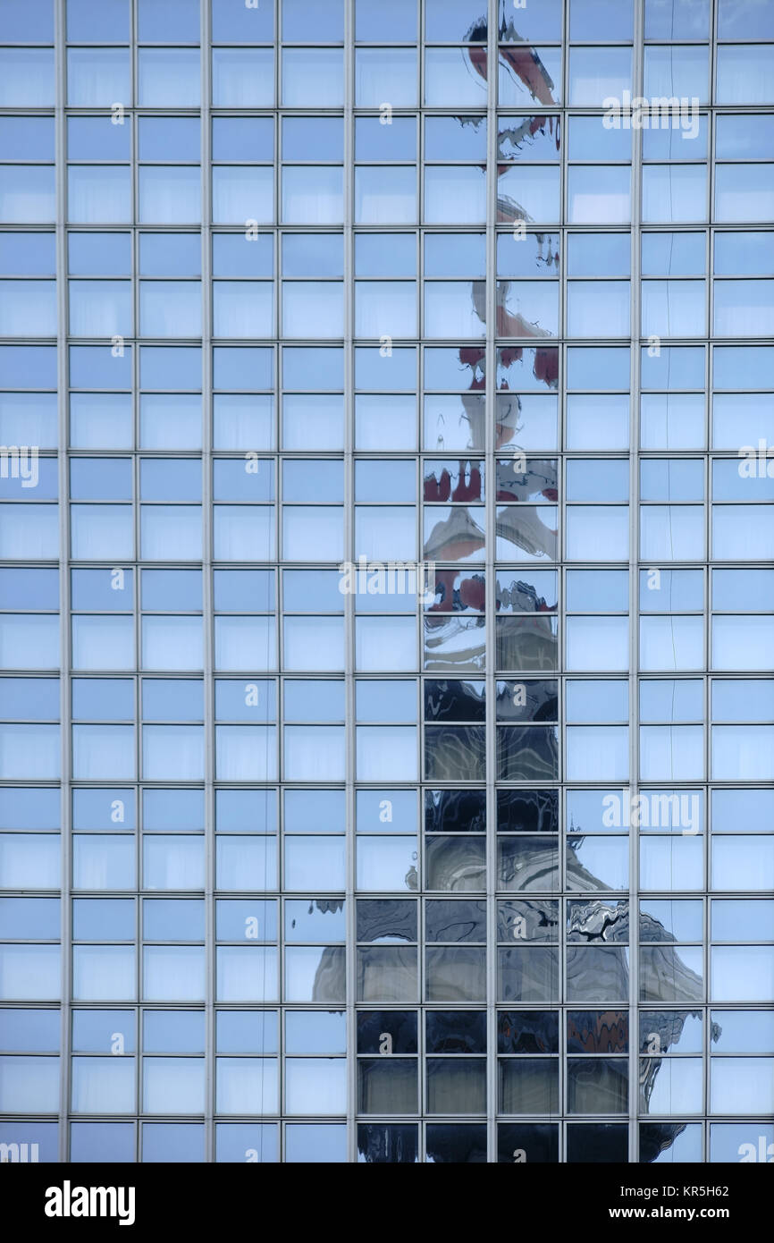 Ein Teil des Berliner Fernsehturmes spiegelt sich in den Fenstern von Hochhauses mit dem blauen Himmel. Banque D'Images