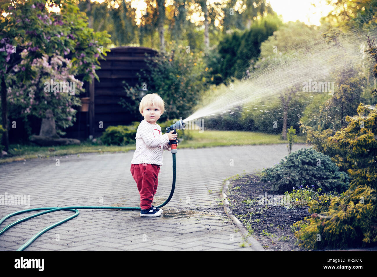 Baby Girl avec un tuyau de jardin Banque D'Images