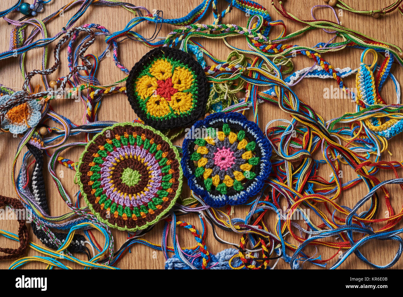 Différents types de bracelets colorés tricotés et boucles d'sont chaotiquement allongé sur la table. En bas à gauche il y a trois grosses étoffes amule Banque D'Images