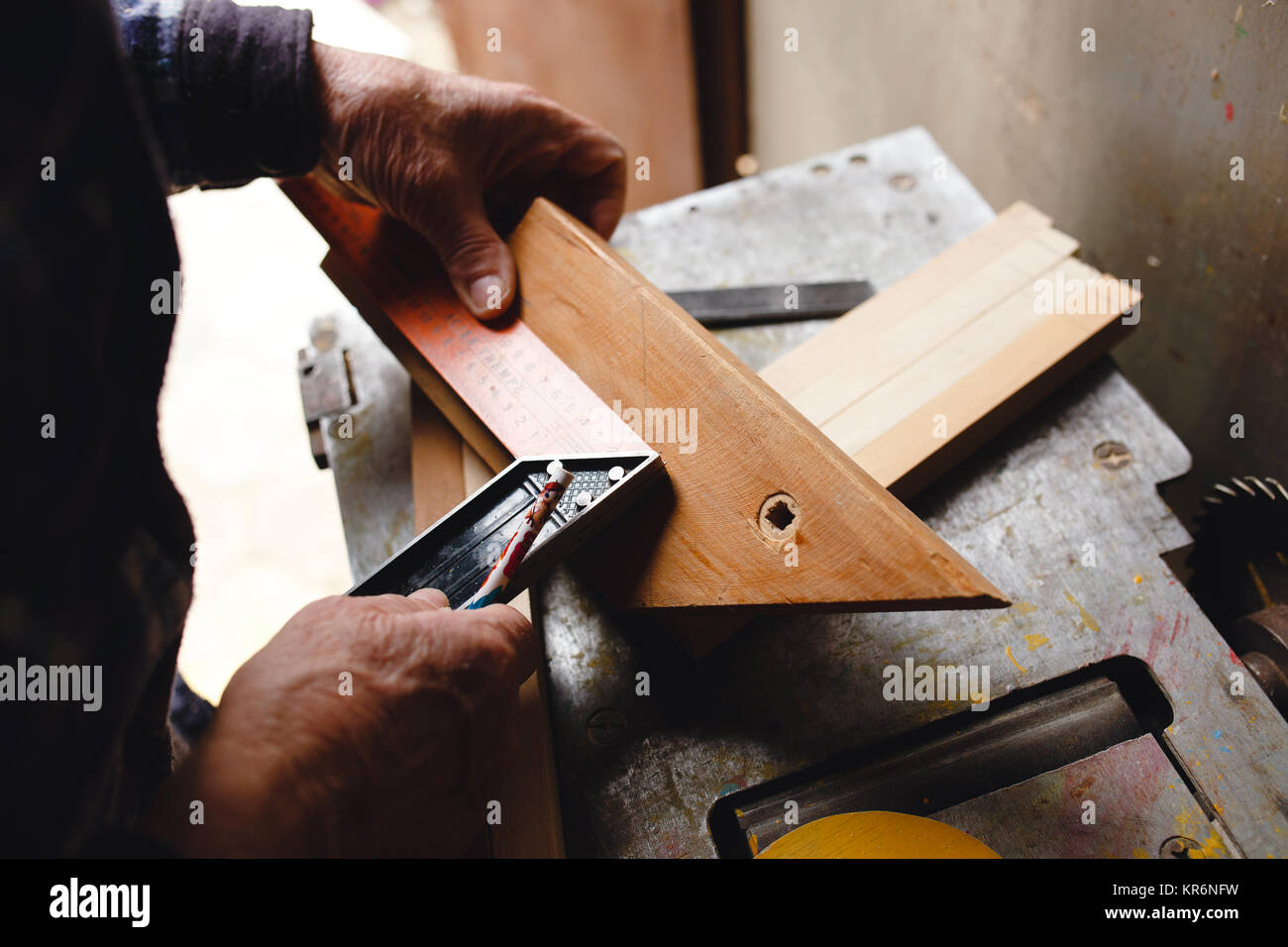 Ancien chef de prendre la mesure d'une planche de bois. Banque D'Images
