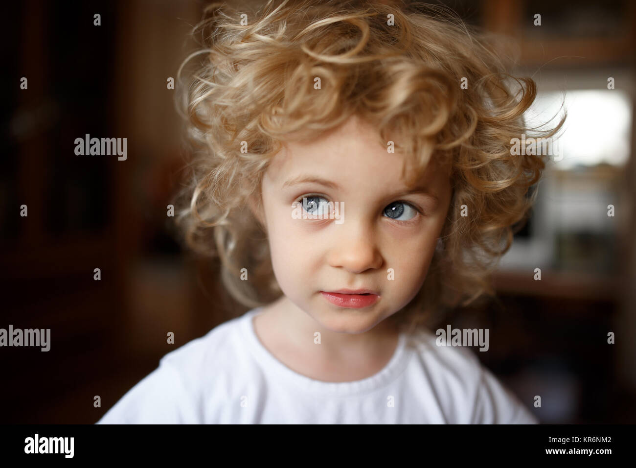 Portrait de l'adorable petite fille blonde avec les cheveux bouclés. Banque D'Images