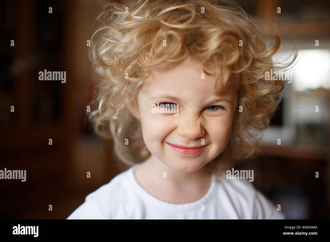 Portrait de l'adorable petite fille blonde avec les cheveux bouclés. Banque D'Images