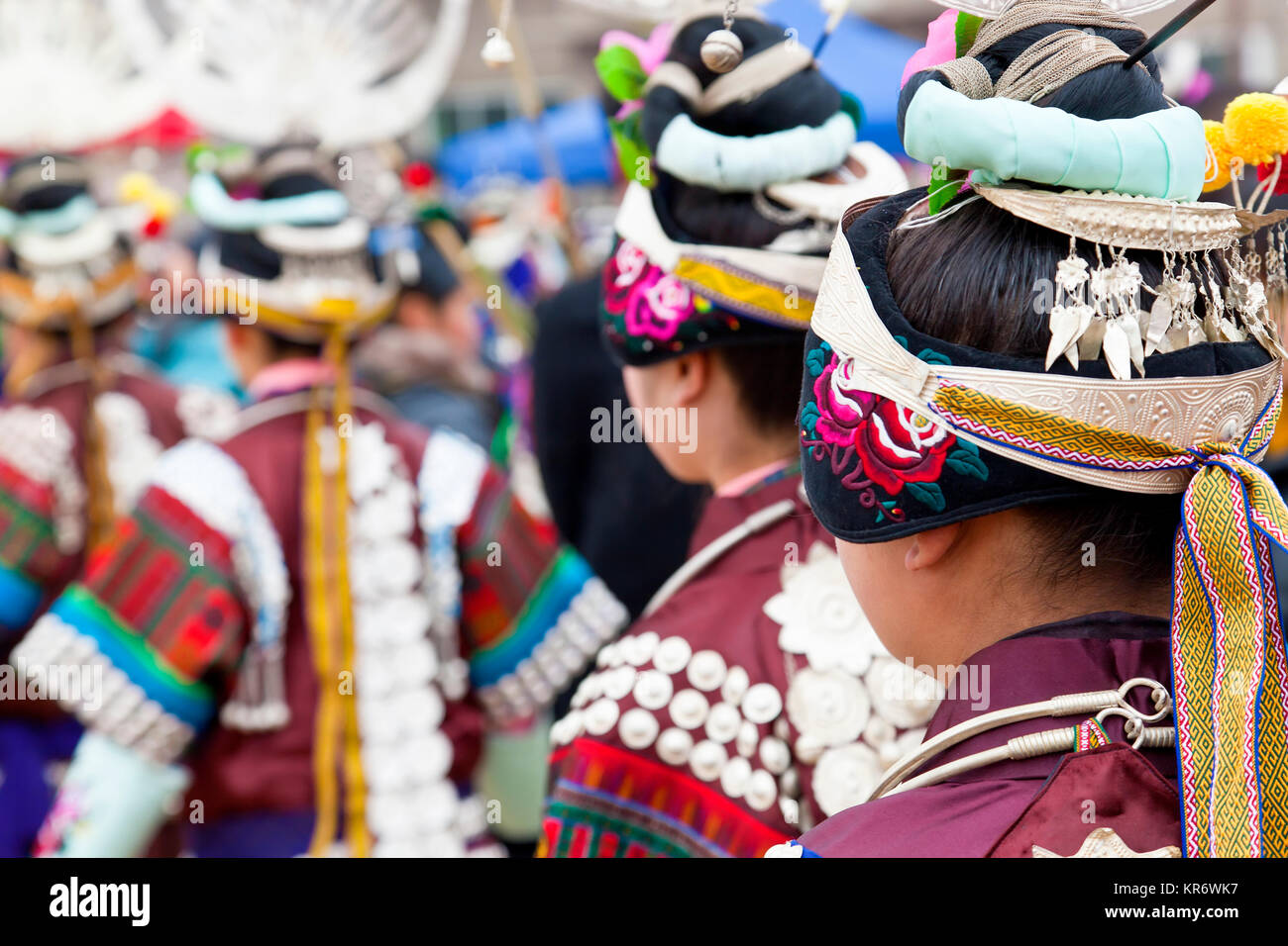 Vue arrière des filles portant des costumes chinois traditionnels colorés et coiffures à danser à un festival. Banque D'Images