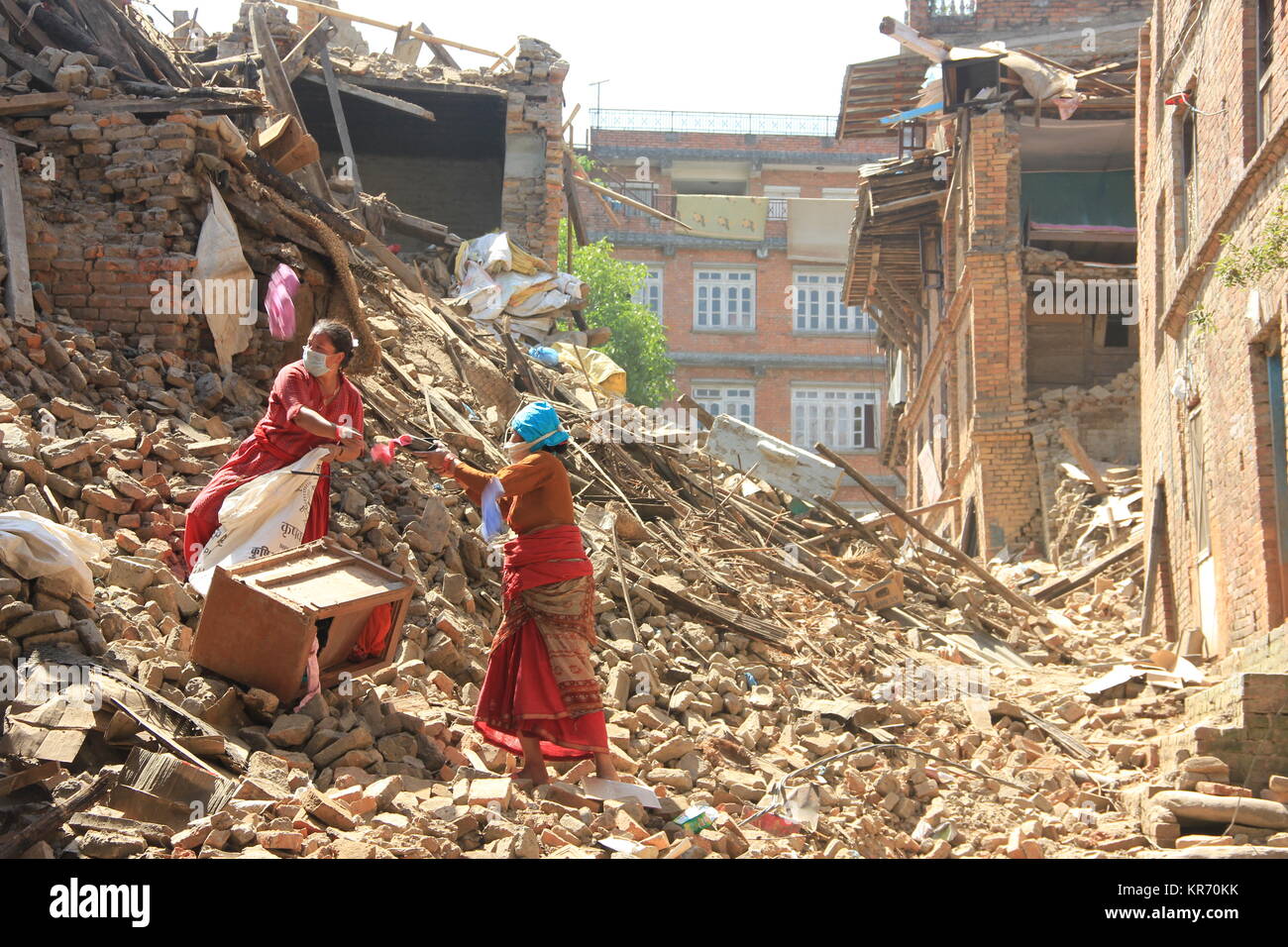 Les femmes dans l'khu appartenant après leurs maisons sont endommagées sur un séisme de magnitude 7,8 au Népal le 25 avril 2015. Banque D'Images