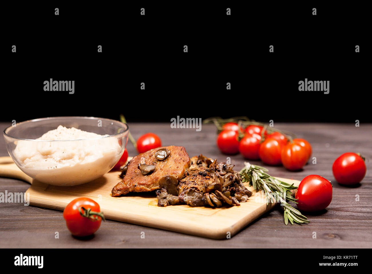 Steak de porc aux champignons, tomates cerise et une plaque avec b Banque D'Images