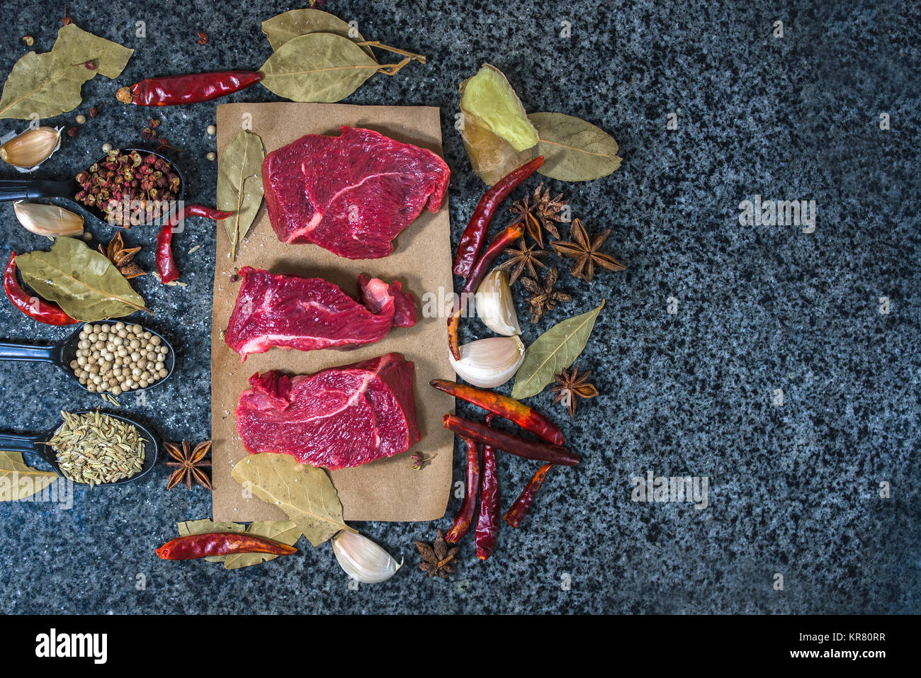 La viande crue. Steak de boeuf sur une planche à découper, de romarin et d'épices. Banque D'Images