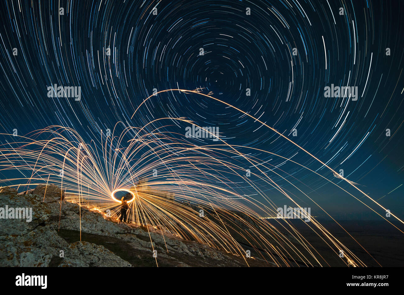 Une longue exposition image montrant star trails plus de forteresse médiévale Enisala et acier whool photographie, peinture de lumière dans la nuit. Banque D'Images