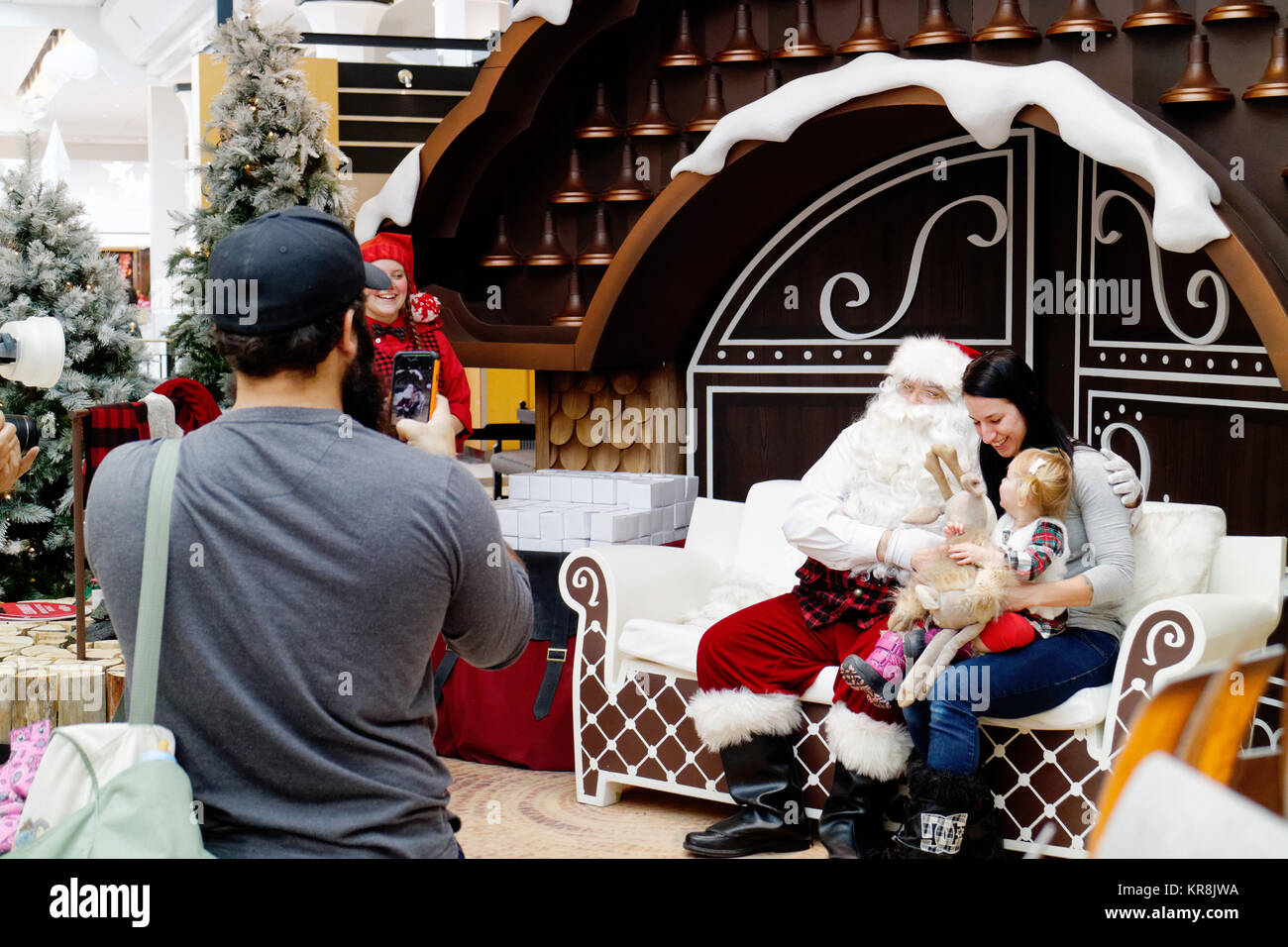 Un père de prendre une photo de sa femme et de son enfant avec le Père Noël dans un centre commercial dans la ville de Québec Banque D'Images