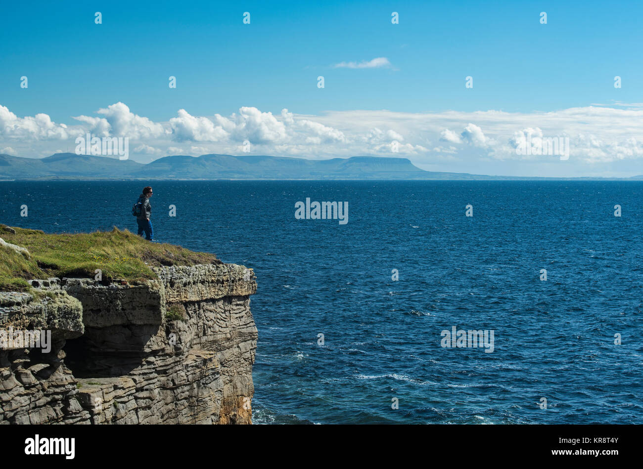 L'Irlande, le comté de Donegal, tête de Muckross, femme debout sur le haut de falaise Banque D'Images
