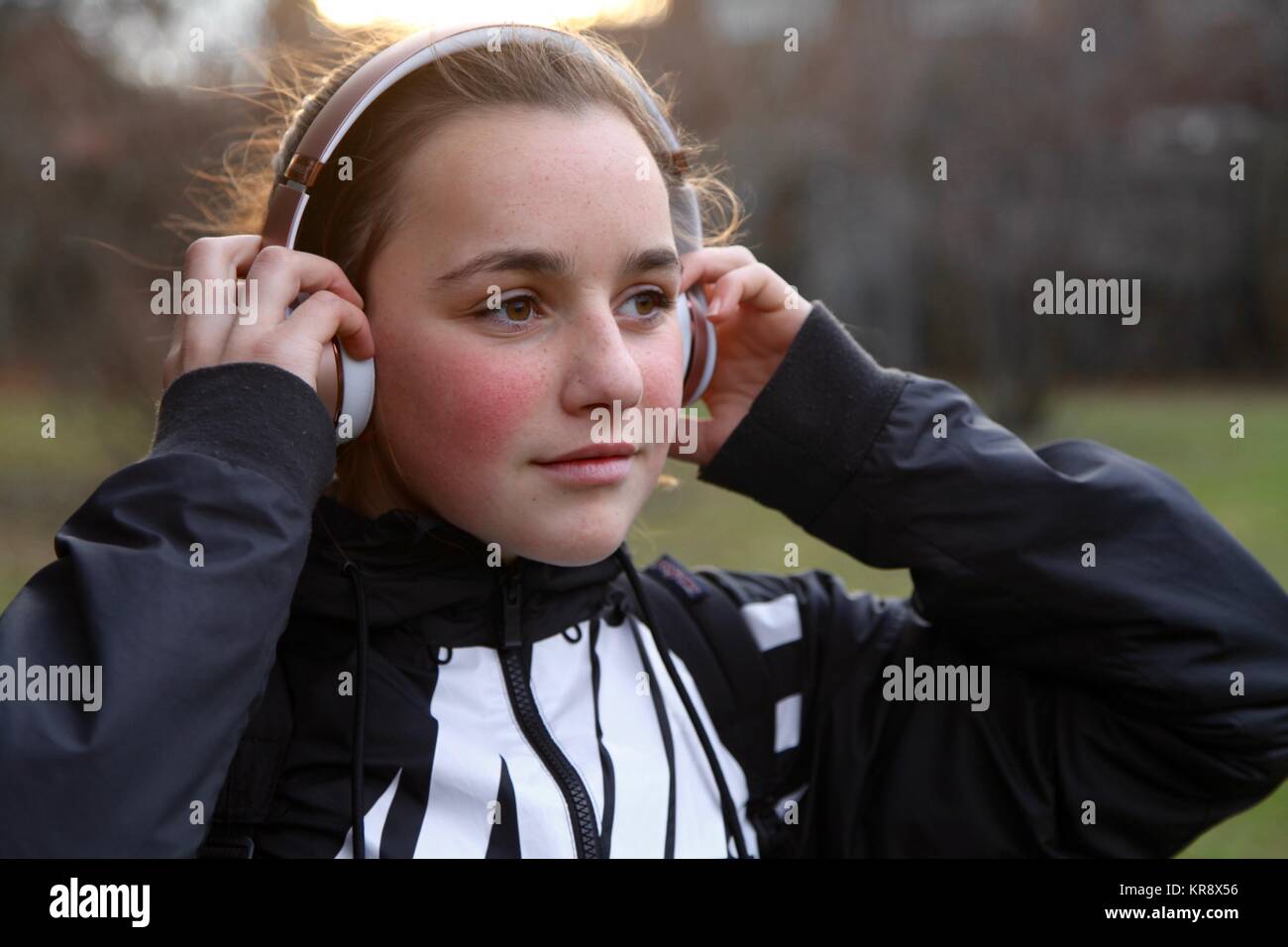 Jeune adolescente à l'écoute de l'or rose casque sans fil Banque D'Images
