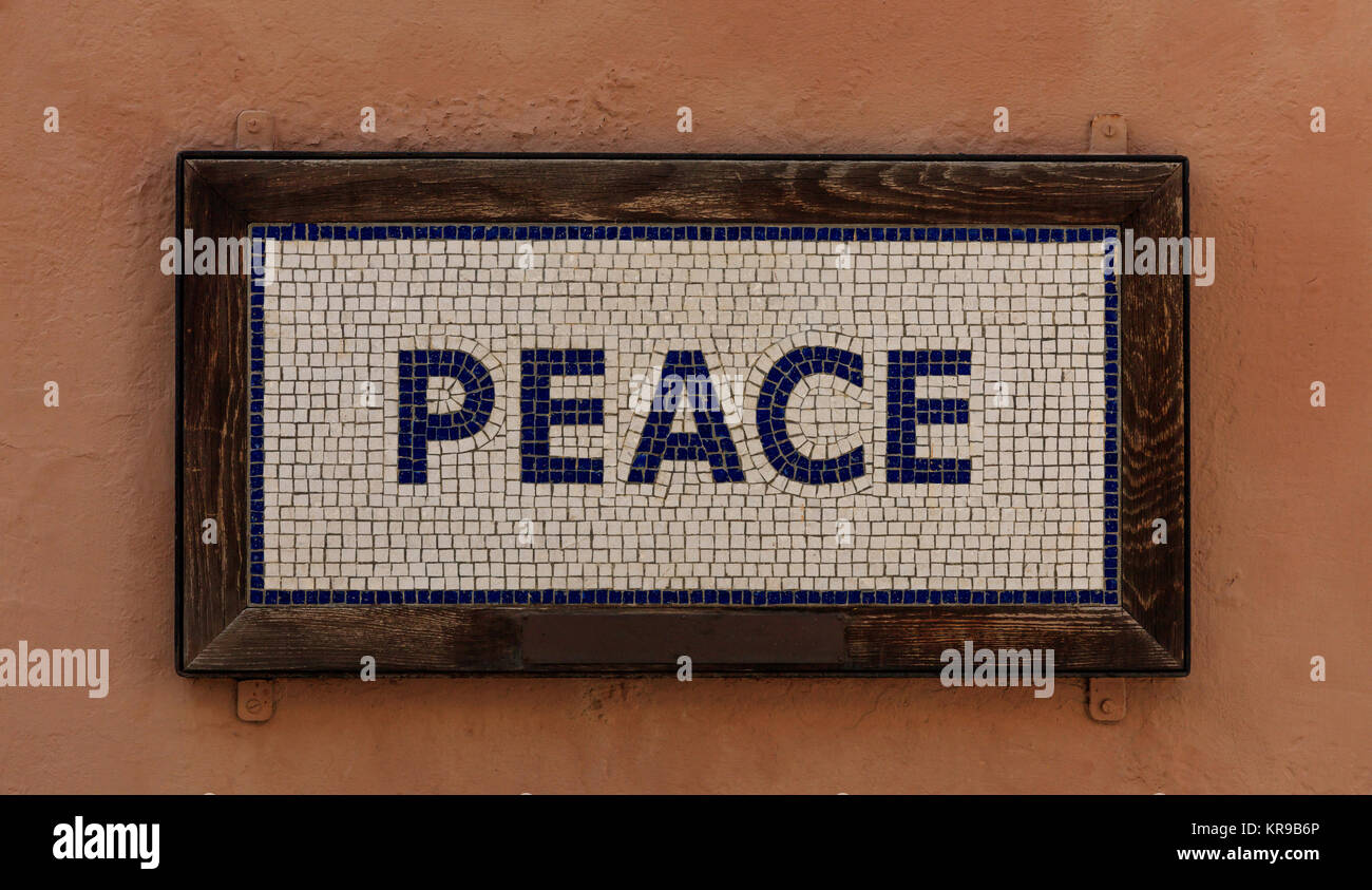 Mot de paix faite à partir de cubes. Motif en mosaïque, cadre en bois, un fond de couleur saumon. Vue en gros plan. Banque D'Images