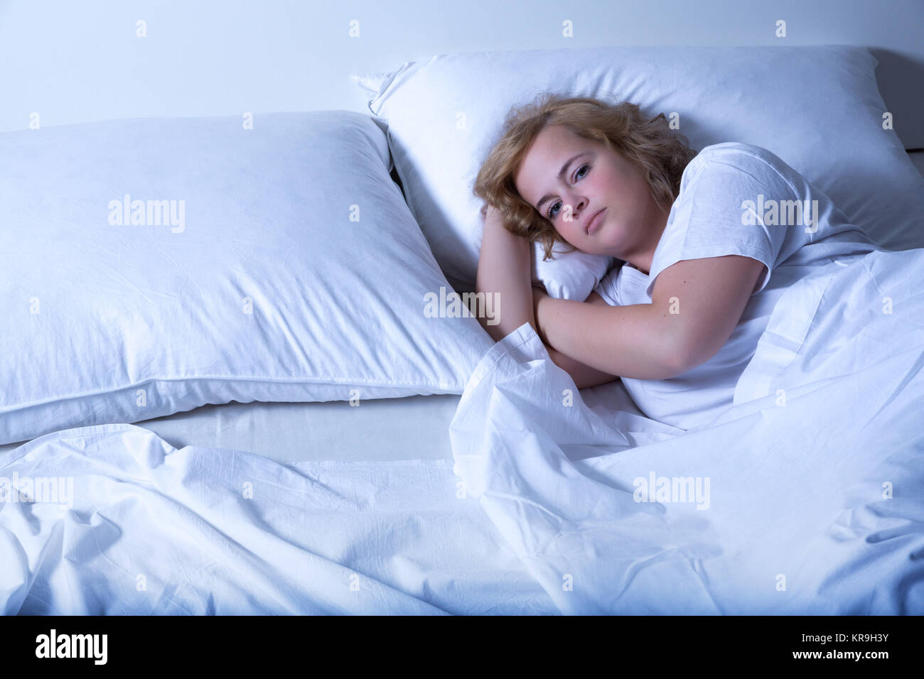 Une jeune femme taille plus dormir dans le lit la nuit. Banque D'Images