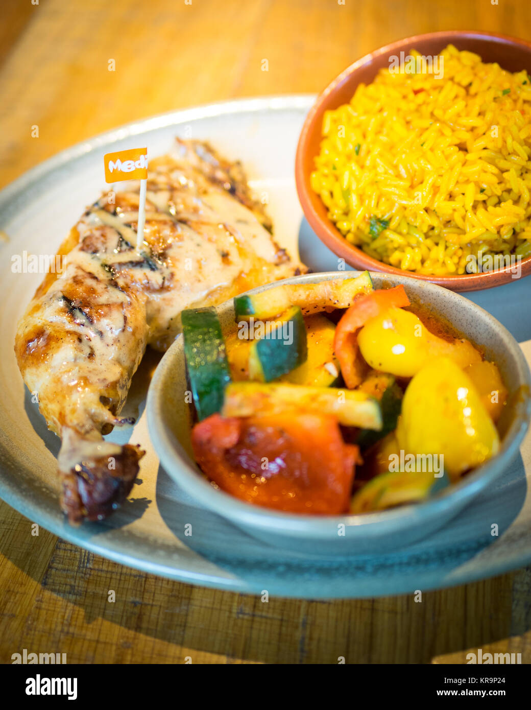 Peri-peri Quart de poulet avec riz épicé de côtés et peri-peri légumes de Nando's, une chaîne de restauration décontractée qui provient d'Afrique du Sud. Banque D'Images