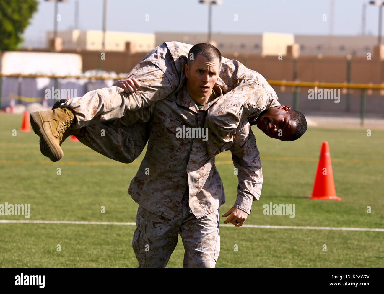 La base navale américaine de Bahreïn (31 déc. 13, 2017) - De La Naval Amphibious Task Force Force, 51/5ème Marine Expeditionary Brigade Le Capitaine Andrew Macon porte le Sgt. Nicholas Smith sur la nouvelle la base navale américaine de softball Bahreïn pendant leur combat annuel la manoeuvre du Fitness Test-sous-le-feu de l'événement. Quel que soit l'âge ou le grade marines sont tenus de procéder à deux tests de condition physique par an, le CFT et un test d'aptitude physique. Le CFT est destiné à garder pour le prêt des Marines de rigueurs physiques des opérations de combat contemporain et est conçu pour simuler un grand nombre de tâches qu'un mari Banque D'Images