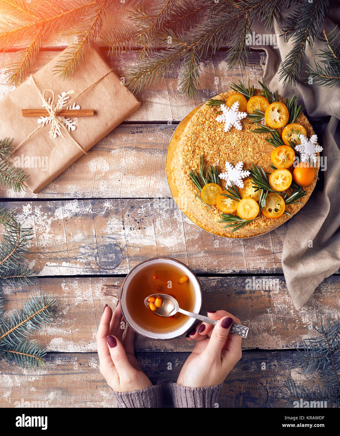 Miel de Noël gâteau sur la table. Femme tenant un plateau avec berry près de décoré présente au petit-déjeuner. Banque D'Images
