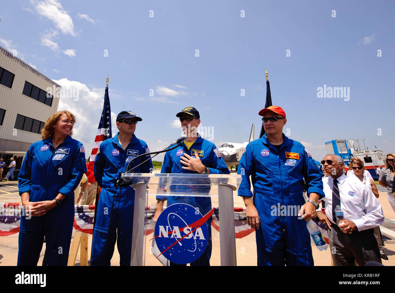 La navette spatiale Atlantis (STS-135) Le capitaine de frégate Chris Furgeson, sur l'estrade, est flanqué de son équipage pilot Doug Hurley, droite, et les spécialistes de mission et Rex Walheim Sandy Mangus, gauche, comme il traite les employés et les entrepreneurs se sont réunis à un événement d'arrêt des roues au Centre spatial Kennedy de la NASA, le jeudi, 21 juillet 2011, à Cape Cape Canaveral, Floride Atlantis retourne à Kennedy tôt jeudi à la suite d'une mission de 13 jours vers la Station spatiale internationale (ISS) et marquant la fin de la période de 30 ans du Programme de la navette spatiale. Dans l'ensemble, l'Atlantide a passé 307 jours dans l'espace et parcouru près de 126 millions de kilomètres au cours de sa Banque D'Images