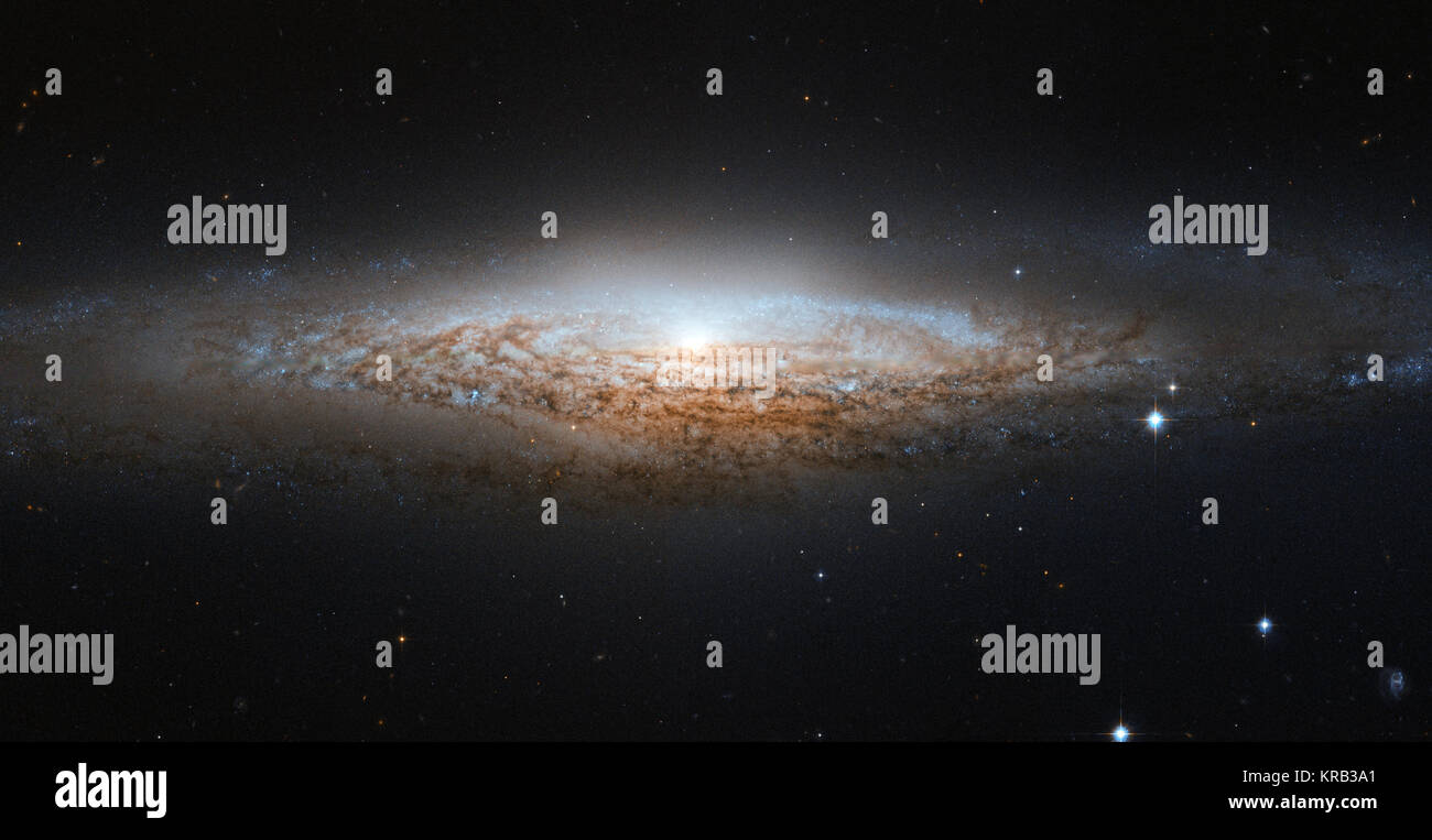 La NASA/ESA Hubble Space Telescope a repéré un OVNI - eh bien, l'OVNI Galaxie, pour être précis. NGC 2683 est une galaxie spirale vue presque par la tranche, lui donnant la forme d'un vaisseau de science-fiction classique. C'est pourquoi les astronomes de l'astronaute planétarium et Observatoire Memorial lui a donné ce surnom. Bien qu'une vue d'ensemble nous permet de voir la structure détaillée d'une galaxie (comme cette image de Hubble une spirale barrée), une vue latérale a ses propres avantages. En particulier, il donne aux astronomes une excellente occasion de voir le fragile environnement poussiéreux ruelles du bras spiraux silhouetté ag Banque D'Images