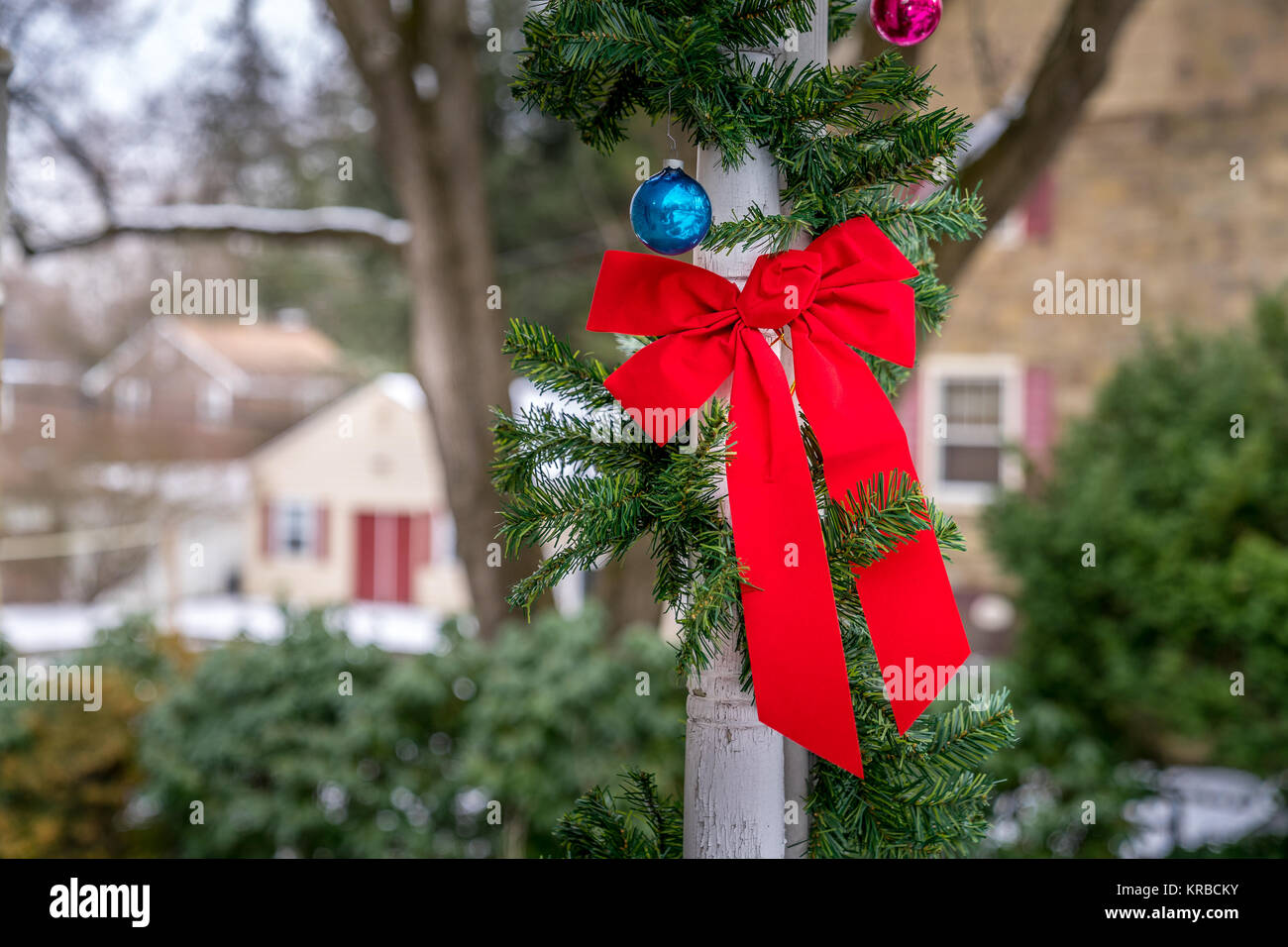 Rad noeud papillon, des ornements de Noël et décoration evergreen ornent les colonnes de bois. Célébration traditionnelle, des fêtes de Noël et d'hiver Banque D'Images