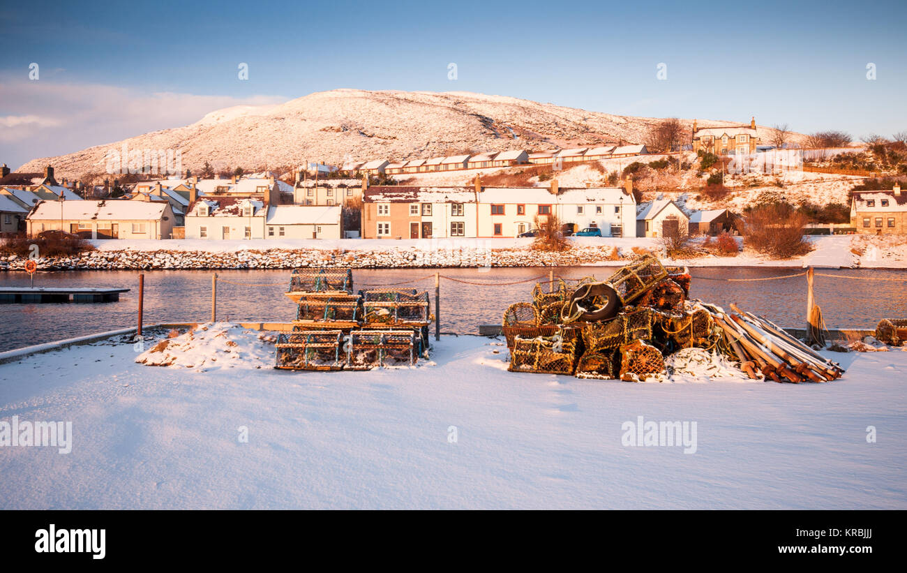 Des casiers à homard se trouvent parmi la neige vierge sur la digue de Helmsdale Harbour sur la côte de Moray Firth Sutherland dans l'extrême nord des Highlands Sc Banque D'Images