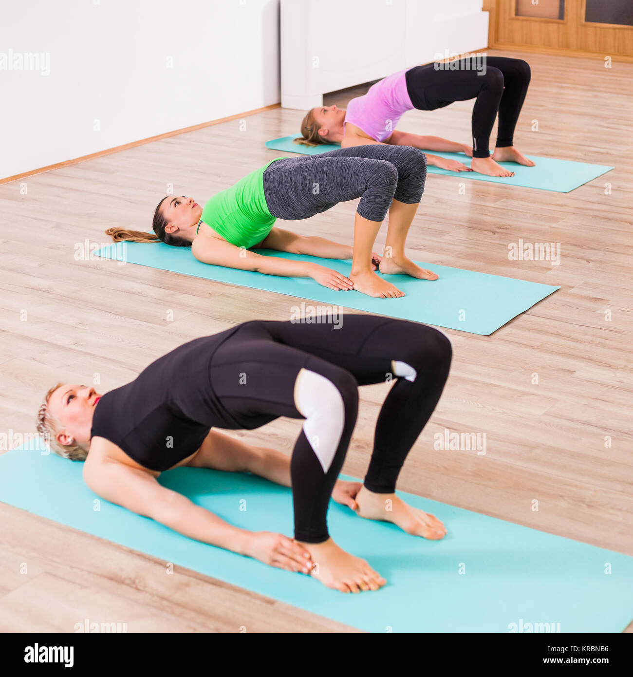 Trois jeunes filles pratiquant le yoga, Setuasana / Petit Pont poser Banque D'Images