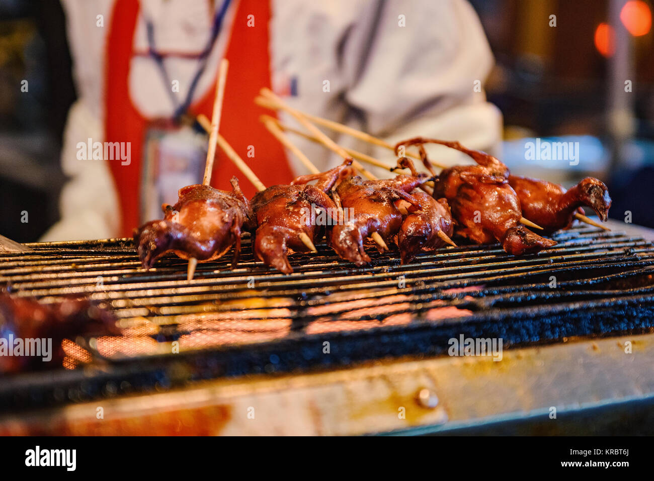 Pigeons sur un grill dans un marché alimentaire chinois. Banque D'Images